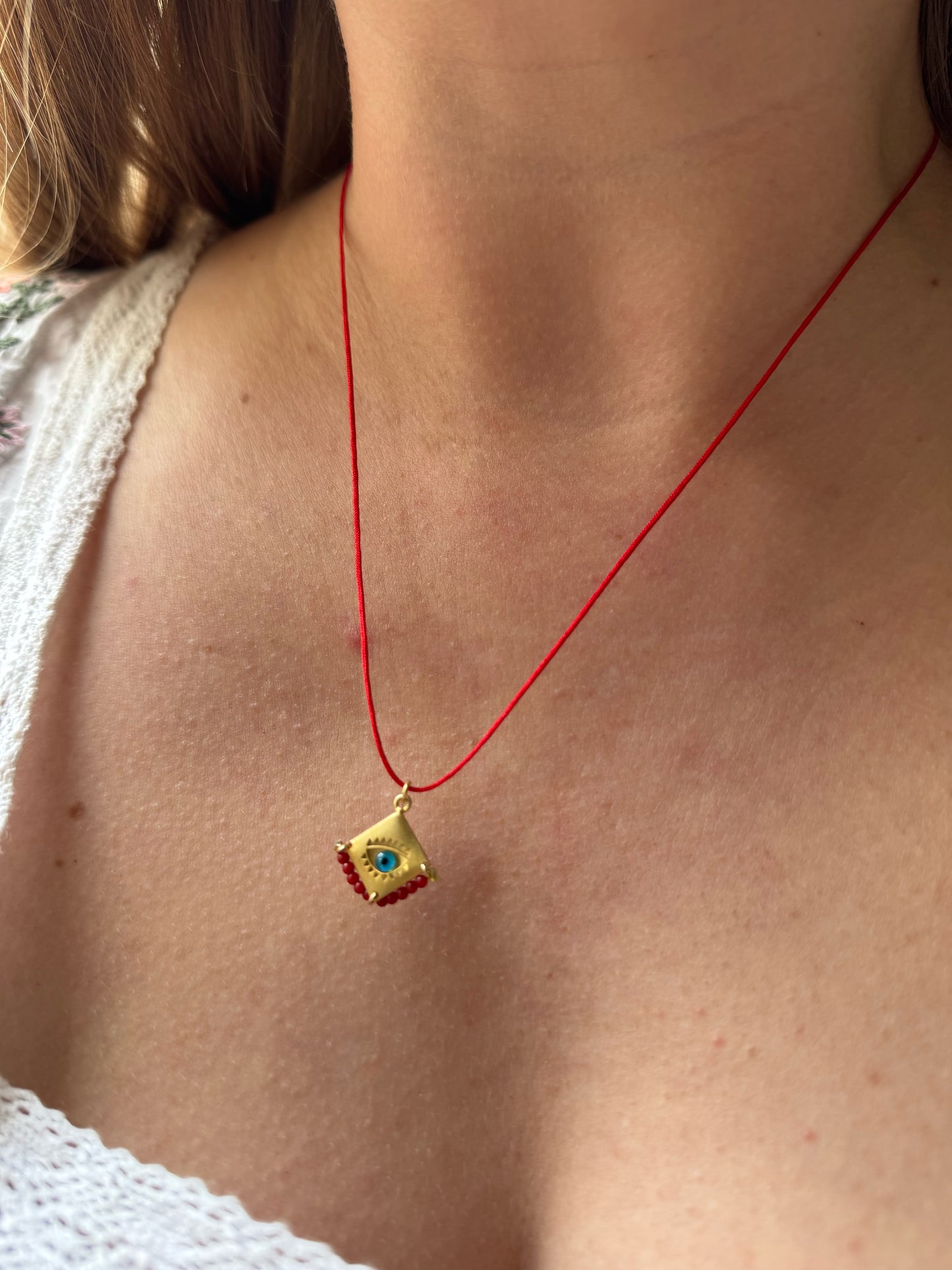 Blue eye amulet on a red string