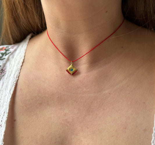 Blue eye amulet on a red string