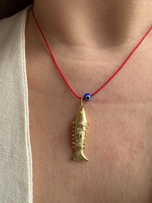 Articulated fish on a red string necklace