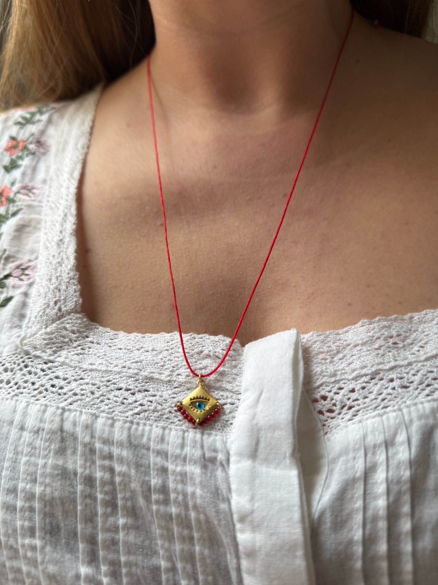 Blue eye amulet on a red string