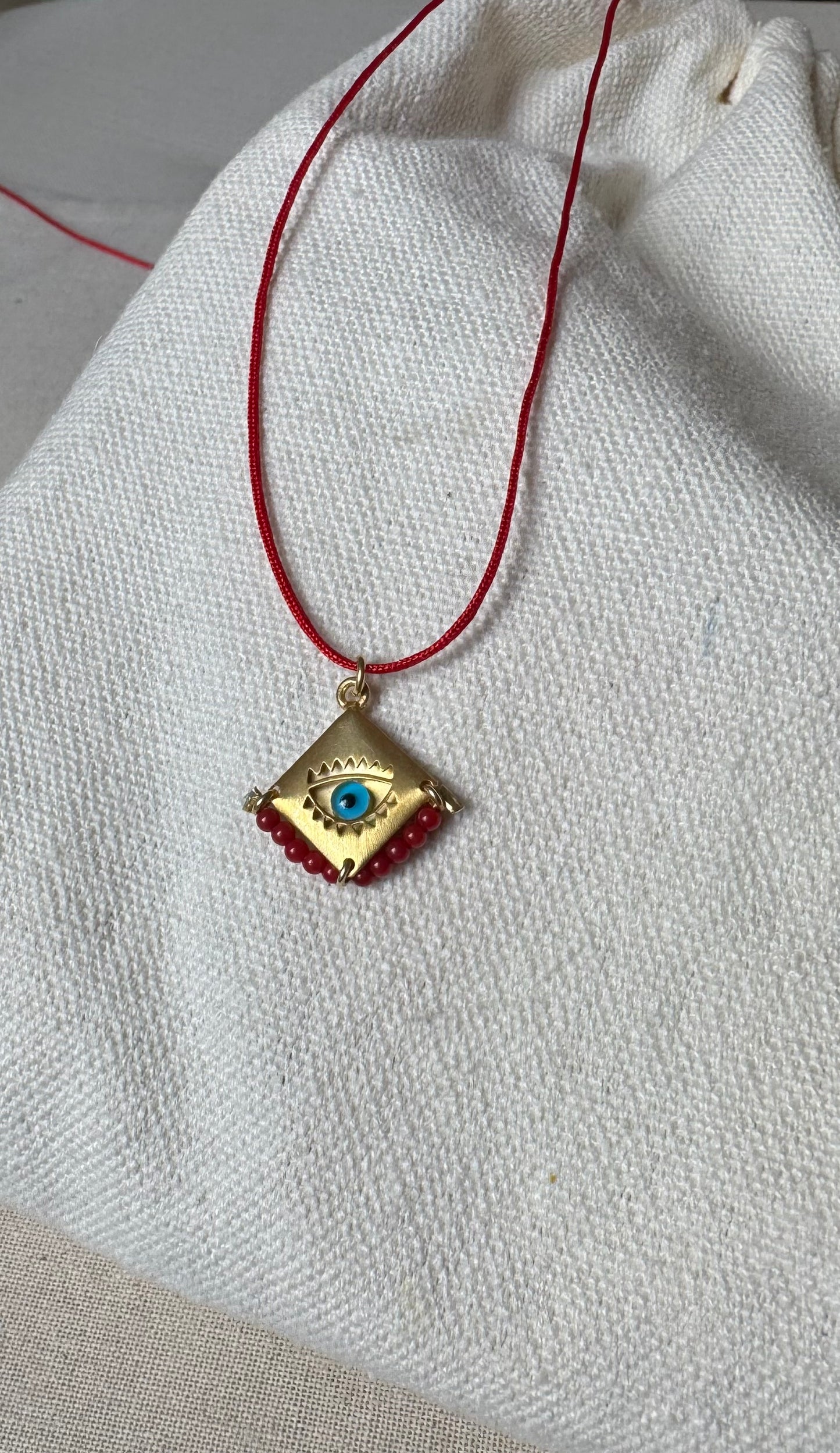 Blue eye amulet on a red string
