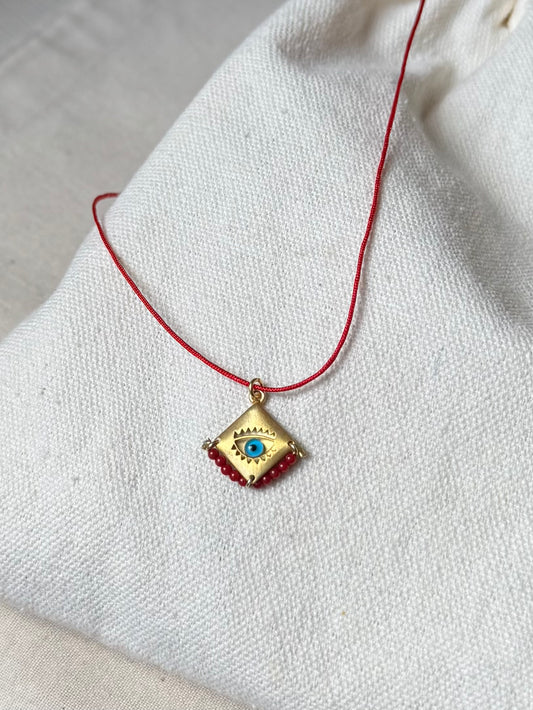 Blue eye amulet on a red string
