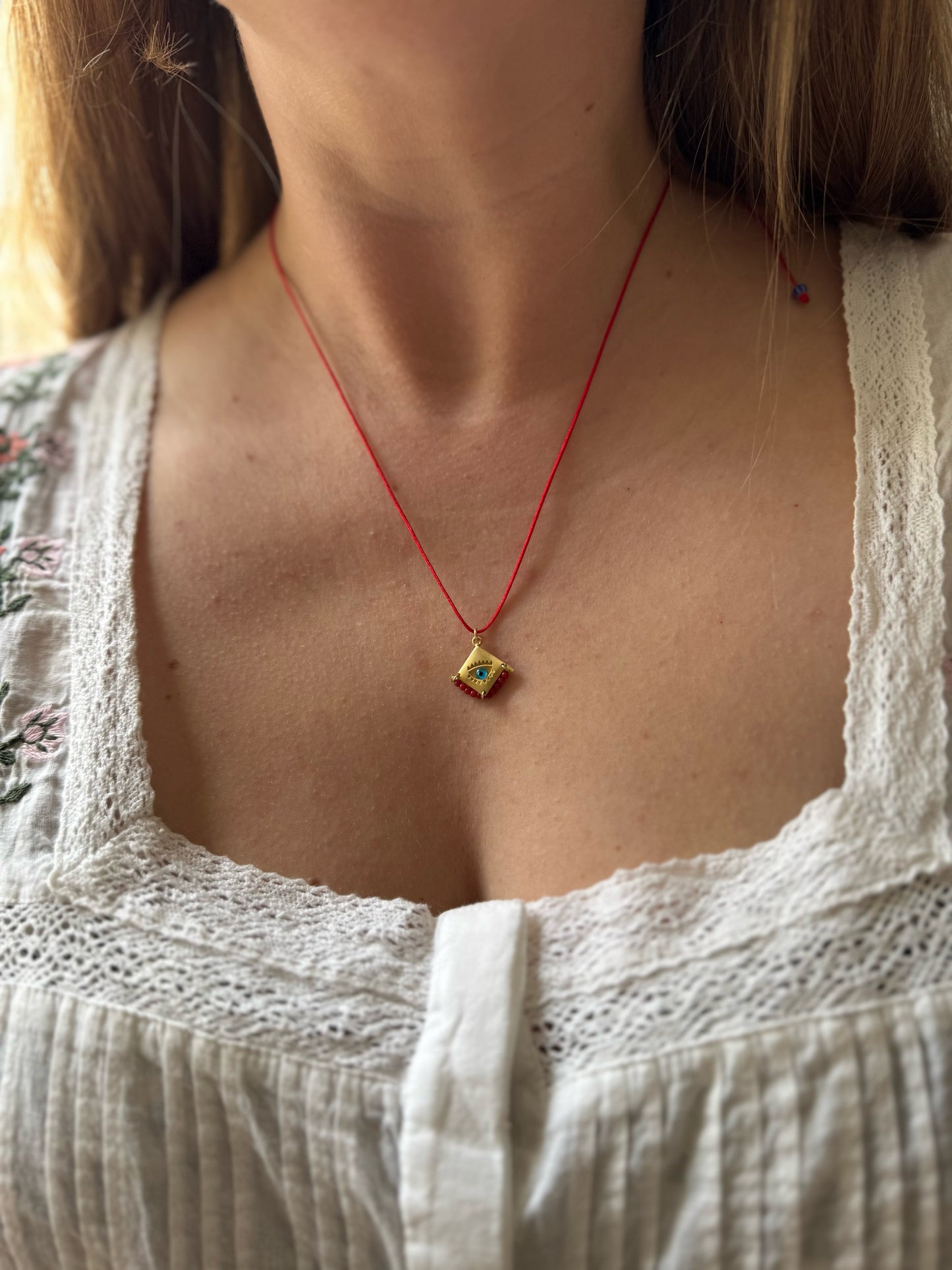 Blue eye amulet on a red string