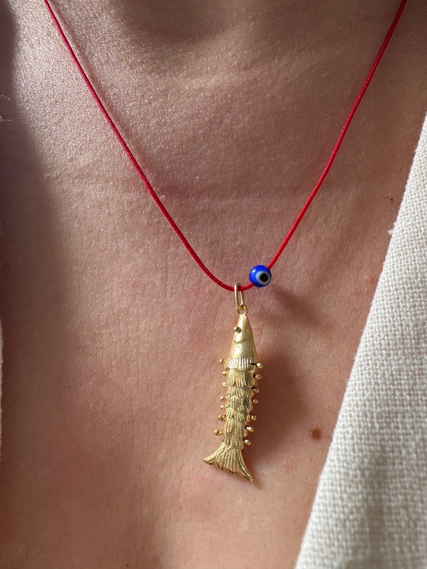 Articulated fish on a red string necklace